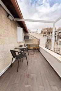 a patio with a table and chairs on a balcony at ARISTO Machne Yehuda boutique apartments in Jerusalem