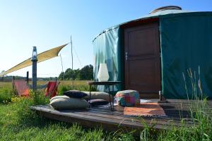 a yurt with a wooden deck in a field at Dzika Jurta na Łebkach in Łebki