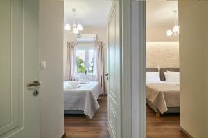 a view of a bedroom with two beds and a window at Luxurious house near the sea in Kato Daratso