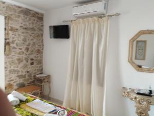 a room with a white curtain and a television at Villa Elli in Ammouliani