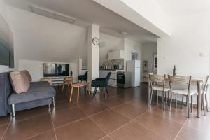 a living room with a couch and a table and chairs at ARISTO Machne Yehuda boutique apartments in Jerusalem