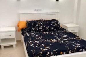 1 dormitorio con 1 cama con edredón y almohadas azules en appartement plage petit paradis 