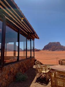 a building with a table and chairs in the desert at Salameh's Bedouin Camp in Wadi Rum