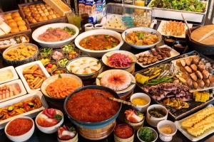 un buffet con muchos tipos diferentes de comida en una mesa en La Vista Hakodate Bay, en Hakodate