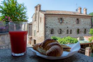阿爾庫阿佩特拉爾卡的住宿－Borgo Petrarca，桌上的面包和一杯果汁