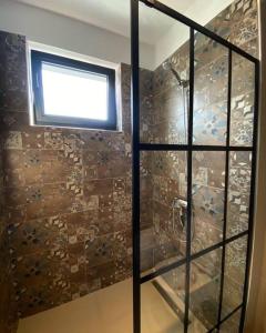 La salle de bains est pourvue d'une douche et d'une fenêtre. dans l'établissement Sara blue apartment, à Tirana
