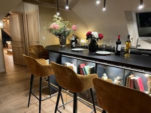 a kitchen with a bar with chairs and books at Amour Amour Love Room in Penvénan