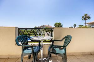 einen Tisch und zwei Stühle auf einem Balkon in der Unterkunft Quinta do Paiva - Two Bedroom Apartment Olhos de Agua in Albufeira