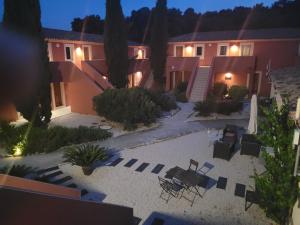 une cour d'une maison avec des chaises et des lumières dans l'établissement Hôtel Domaine le Milos, à Castries