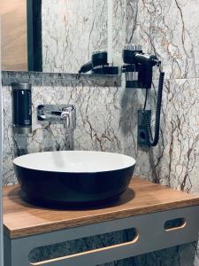a bathroom counter with a sink and a mirror at Intergroup Business & Design Hotel Ingolstadt in Kösching