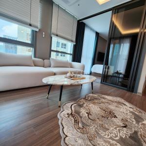 salon z kanapą i stołem w obiekcie Sienna Ambassador Residence w Pusanie