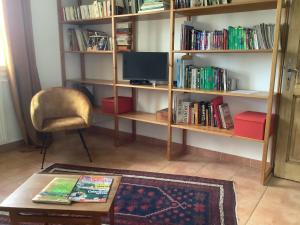 a living room with a book shelf filled with books at Mas des Oliviers in Martigues