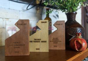 a table with three wooden signs on a table with a vase at Hotel Wine Palace in Tbilisi City