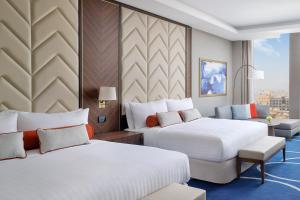 a hotel room with two beds and a chair at Jeddah Marriott Hotel Madinah Road in Jeddah +139 photos