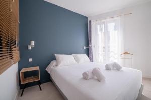 a blue bedroom with a bed with towels on it at L'ESCAPADE in Cannes