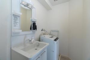 a white bathroom with a sink and a refrigerator at ELLE Namba 6 in Osaka +38 photos