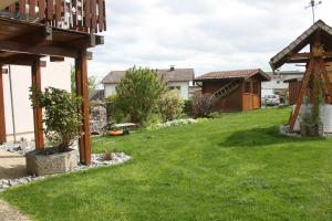 a yard with green grass and a wooden pergola at Ferienwohnung Butz in Lottstetten