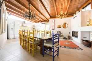 une salle à manger avec un plafond en bois, une table et des chaises dans l'établissement Casa con vistas increíbles, piscina Infinity y jardín con rincones preciosos, à Las Rozas de Madrid