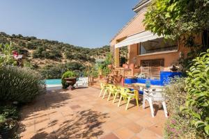 a patio with chairs and a table and a pool at Casa con vistas increíbles, piscina Infinity y jardín con rincones preciosos in Las Rozas de Madrid