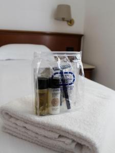 a plastic bag on a bed with towels at La Camogliese Hotel B&B in Camogli