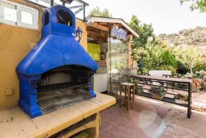 un four à pizza bleu assis sur le côté d'un bâtiment dans l'établissement Casa con vistas increíbles, piscina Infinity y jardín con rincones preciosos, à Las Rozas de Madrid