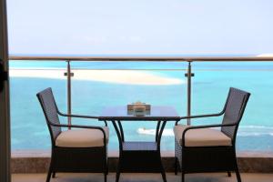 Triumph White Sands Hotel في مرسى مطروح: طاولة وكراسي مطلة على المحيط