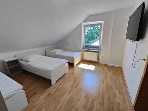 a small room with two beds and a window at SANO Apartments - DGL - Hagen Zentral - vollausgestattete Küche - Internet - Platz für bis zu 5 Personen in Hagen