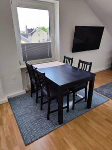 een eetkamer met een zwarte tafel en stoelen bij SANO Apartments - DGL - Hagen Zentral - vollausgestattete Küche - Internet - Platz für bis zu 5 Personen in Hagen