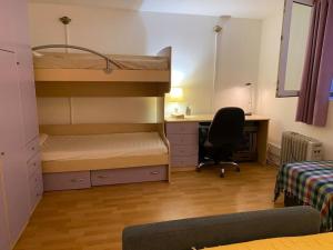 a bedroom with bunk beds and a desk and a chair at Cozy & quiet studio apartment with a garden in Split