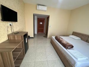 Habitación de hotel con cama y TV de pantalla plana. en Bedouins Inn Village en Áqaba