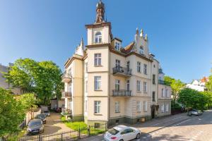 a large white building with a clock tower at Sanhaus Apartments - Apartament LIDO - 300 m od plaży in Sopot