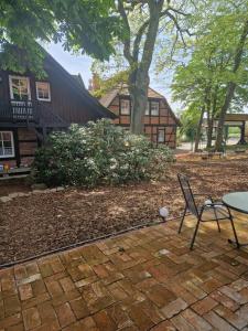 einen Stuhl und einen Tisch vor einem Haus in der Unterkunft Landhotel Michaelishof in Bergen