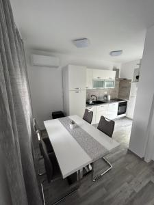 a white table and chairs in a small kitchen at Apartman Petra in Vir