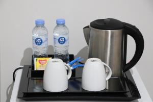 einen Wasserkocher und zwei Flaschen Wasser auf dem Herd in der Unterkunft قمم بارك Qimam Park Hotel 4 in Abha