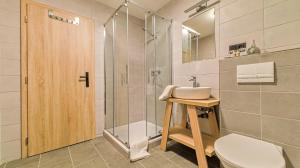 een badkamer met een douche, een wastafel en een toilet bij SALAŠKA penzion in Staré Město