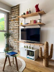 a living room with a tv and a cactus at Le Pagnol - Hyper centre - Clim in Cassis