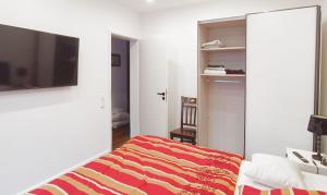 um quarto com uma cama e uma televisão de ecrã plano em Moderne Ferienwohnung direkt am Kanal / Neubau em Emden