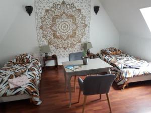 een kamer met een tafel en een bed en een tafel en stoelen bij La belmontaise in Beaumont-sur-Sarthe