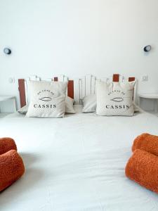 a white bed with two pillows on top of it at Le Pagnol - Hyper centre - Clim in Cassis