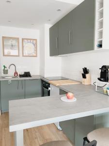 a kitchen with gray cabinets and an apple on a plate at Le Pagnol - Hyper centre - Clim in Cassis