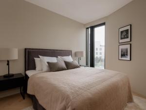 オスロにあるFully serviced luxury apartment at Sommerroの白いベッドルーム(大型ベッド1台、窓付)