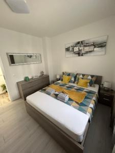 a bedroom with a large bed with yellow and blue pillows at Apartman Petra in Vir