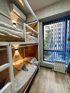 a bedroom with bunk beds and a large window at izzzi hostel in Bishkek