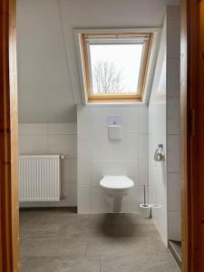 La salle de bains est pourvue de toilettes et d'une fenêtre. dans l'établissement Unieke houten villa met SAUNA in Twente - 6p, à Den Ham