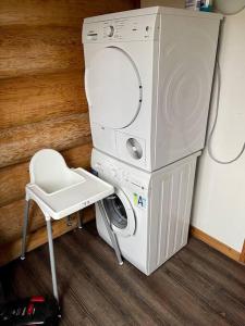 lavadora y secadora en una habitación con silla en Unieke houten villa met SAUNA in Twente - 6p, en Den Ham