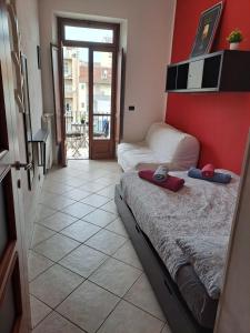 a bedroom with two beds and a red wall at Cozy ROOM STANZA close city center in a family House Stanza in appartamento condiviso noi viviamo in casa STANZA in affitto in Turin