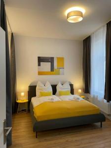 1 dormitorio con 1 cama con sábanas y almohadas amarillas en LUCKY STAYS LS04 - 2 Zimmer - Luxus - Zentrum - große Küche - Aufzug - Smart-TV en Magdeburgo