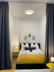 1 dormitorio con 1 cama con almohadas amarillas y blancas en LUCKY STAYS LS04 - 2 Zimmer - Luxus - Zentrum - große Küche - Aufzug - Smart-TV en Magdeburgo