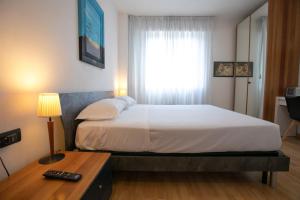 een slaapkamer met een bed, een bureau en een raam bij Mirea's Rooms in Ascoli Piceno