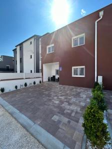 a large brick parking lot in front of a building at Apartman Petra in Vir